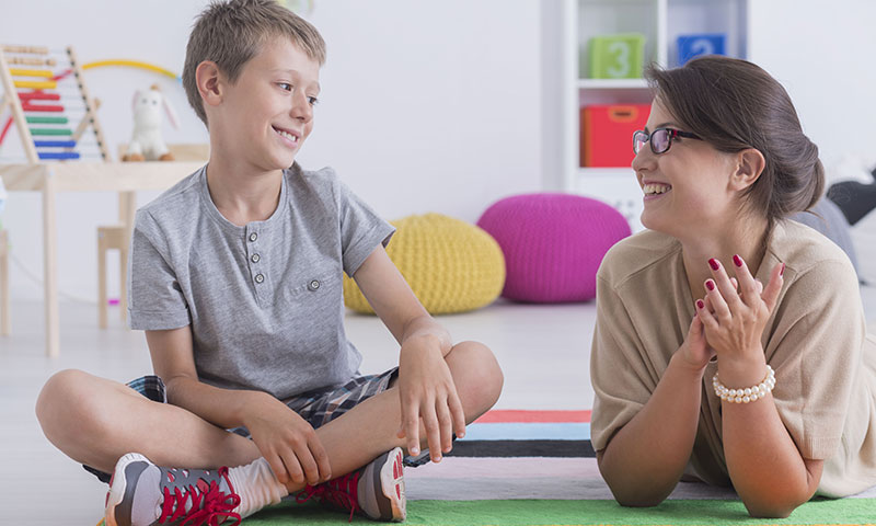 Therapist working with autistic child using educational tools and activities